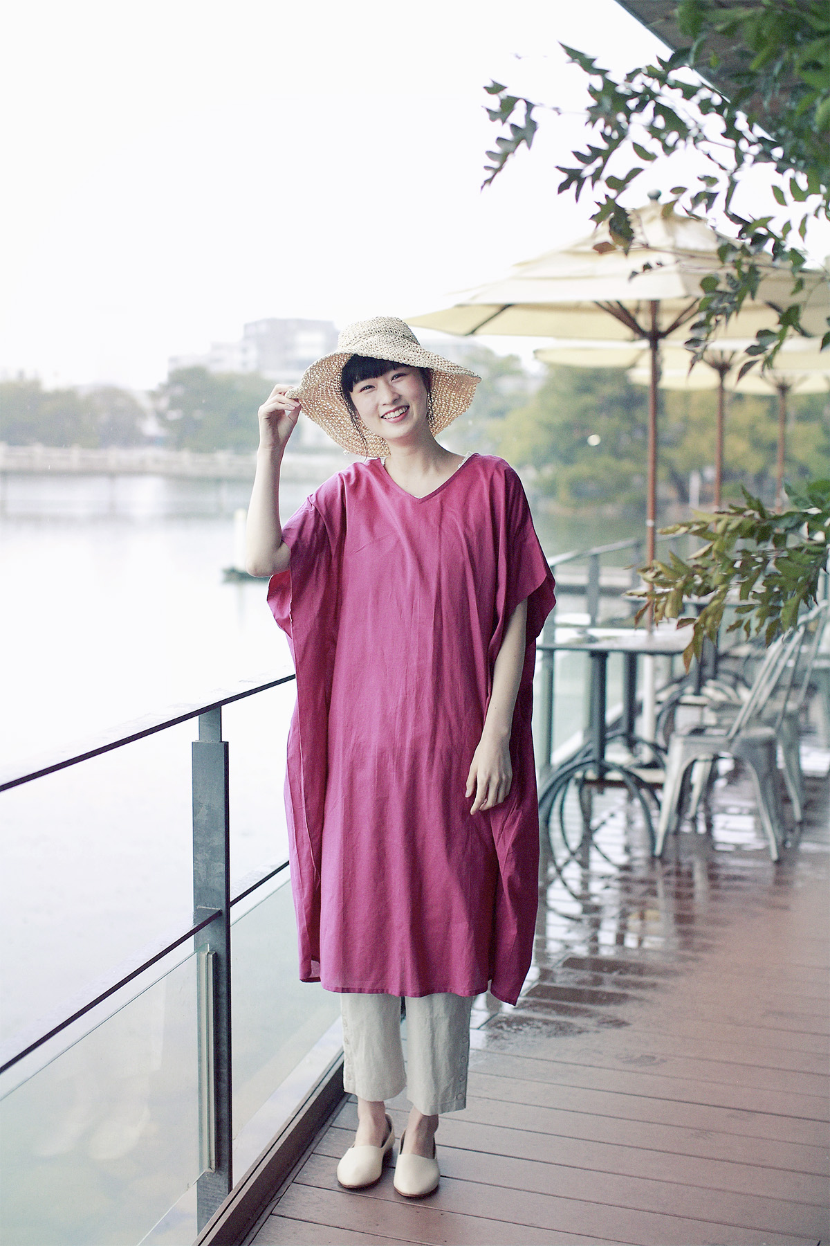 ピンクのワンピースに麦わら帽子のコーディネートの女性モデル写真