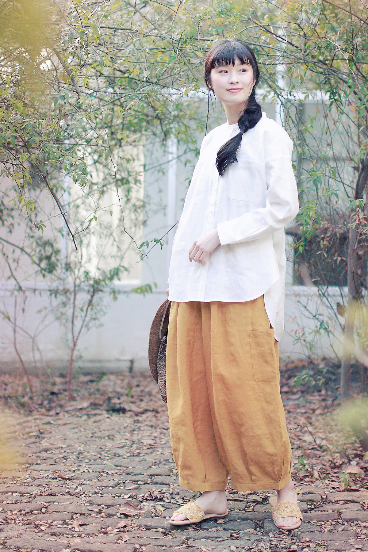 ブラウスとオレンジのパンツのコーディネートの女性モデル写真