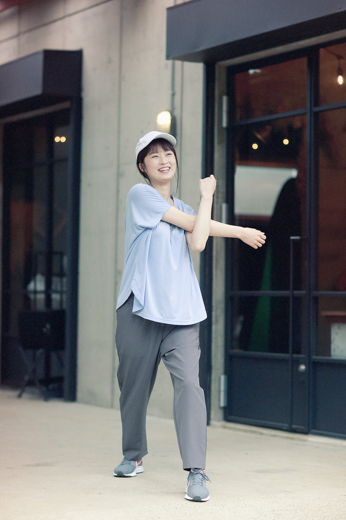 Tシャツでストレッチをする女性モデルの写真