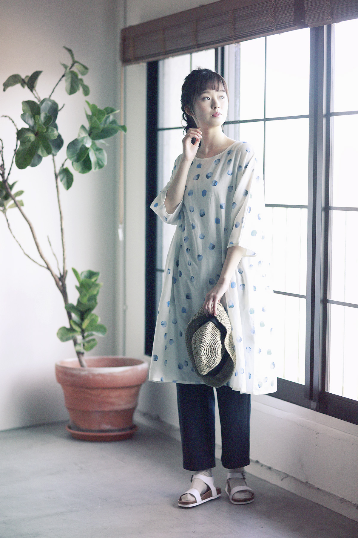 ブルーのドットのシャツと帽子のコーディネートの女性モデル写真