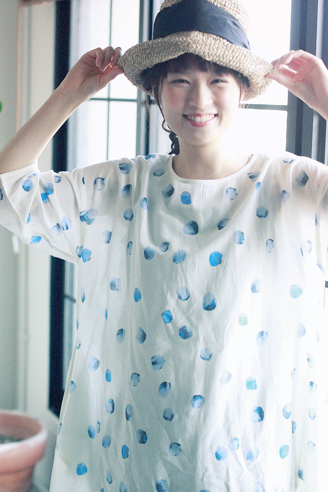 ブルーのドットのシャツと帽子のコーディネートの女性モデル写真