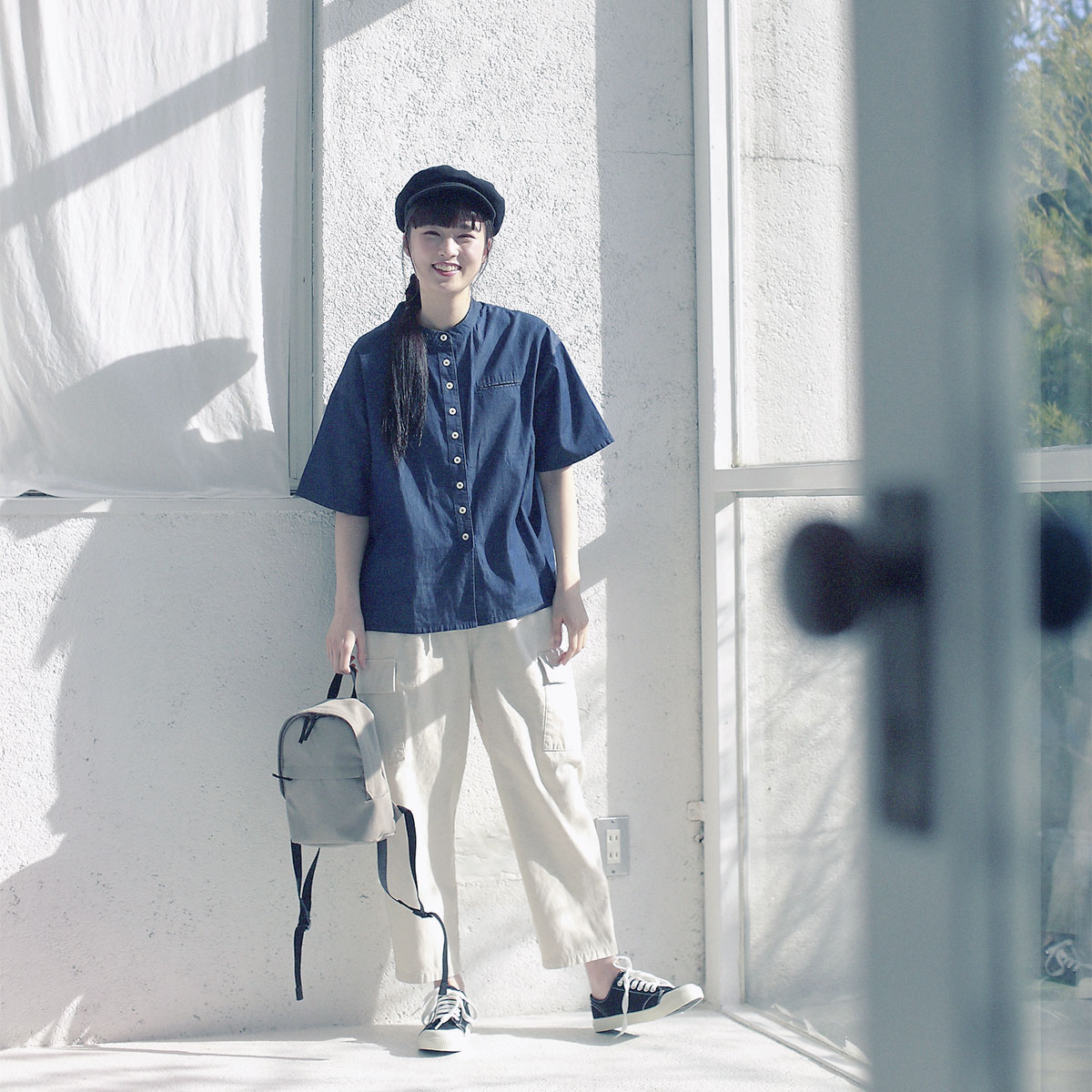 デニムシャツと帽子のコーディネートの女性モデル写真