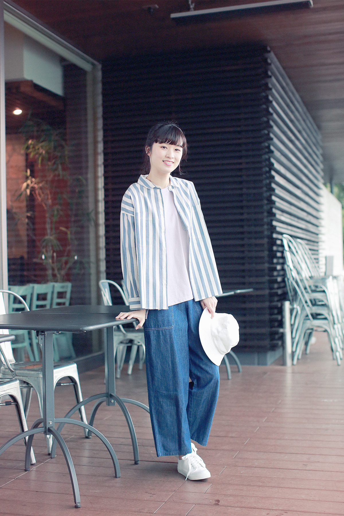 ストライプシャツとデニムパンツの女性モデル写真