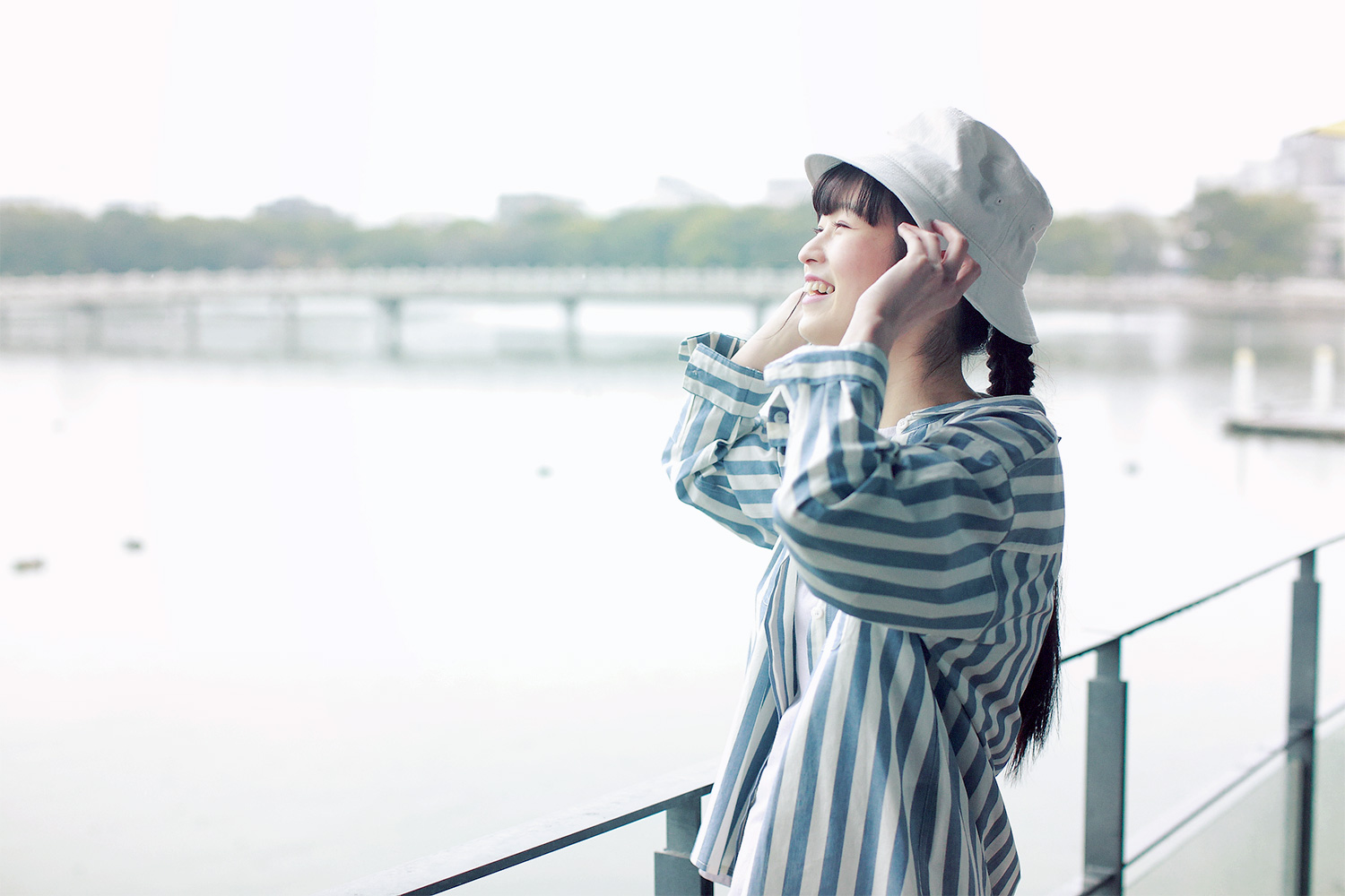 ストライプシャツと帽子のコーディネートの女性モデル写真