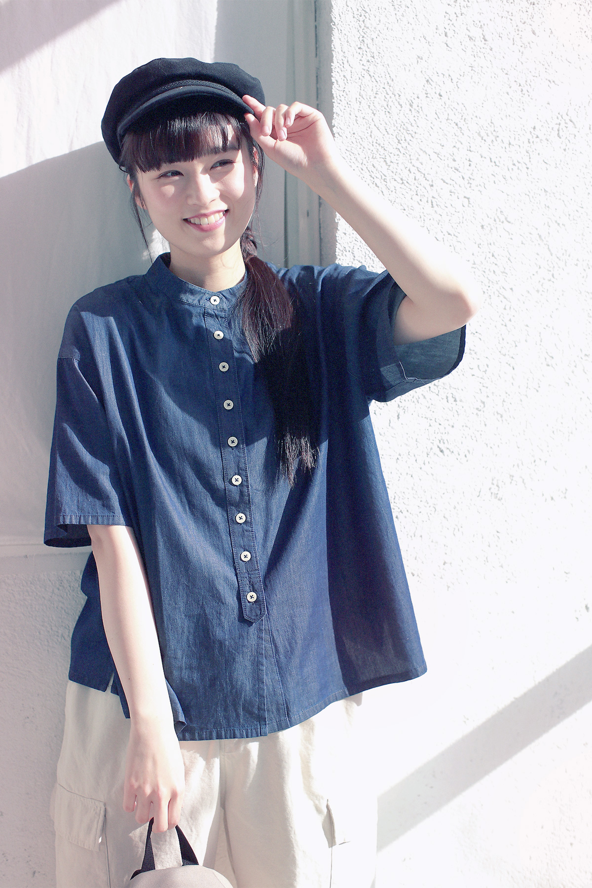 デニムシャツと帽子のコーディネートの女性モデル写真